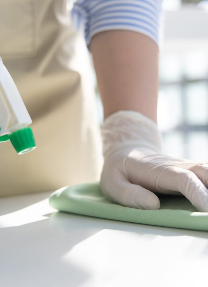 Close up Staff hand Restaurant workers are cleaning table and spraying disinfectants during the virus outbreak, Using cleaning solutions or using alcohol to kill germs in the restaurant.